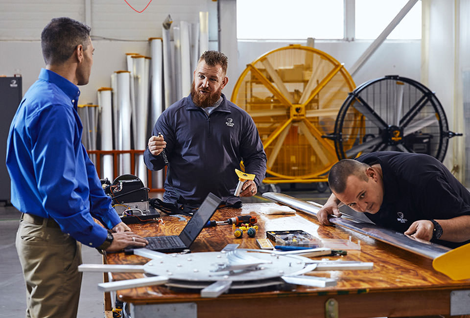 Men working on airfoil blade with AirGo and Black Jack in background